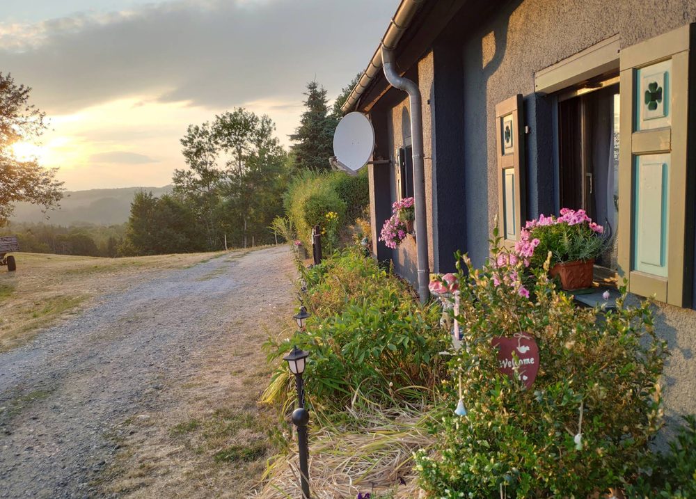 Die Birkenhütte mit rotem Dach in der Abendsonne über den Hügeln der Sächsischen Schweiz